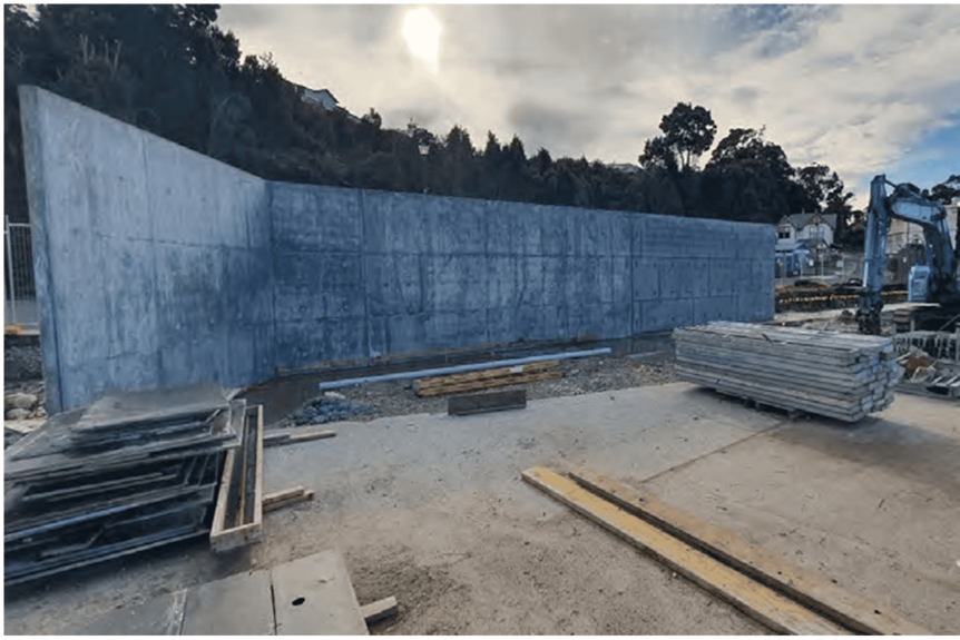 A large concrete wall surrounded by construction equipment.