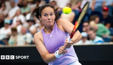 Daria Kasatkina, in a lilac tennis vest, plays a two-handed backhand shot as her eyes suggest intense focus