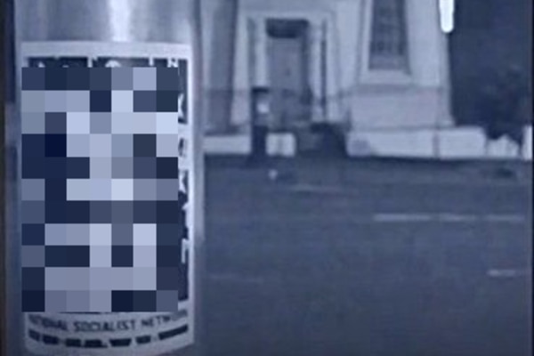 A National Socialist Network sticker, which the ABC has chosen to blur, stuck on a pole across from the Hobart Synangogue.