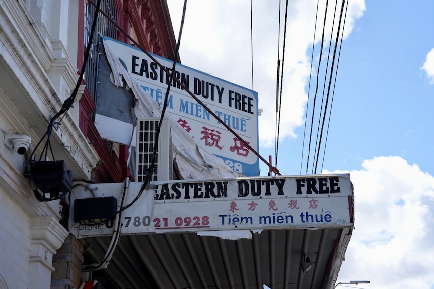 Tattered signage above a duty free shop in Victoria Street, Richmond