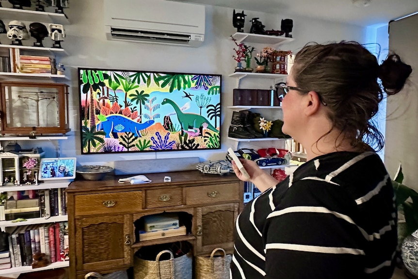 A woman turning on the air conditioning