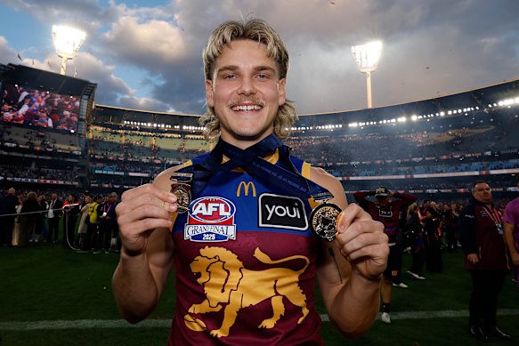 Father-son Lion Will Ashcroft holds his Norm Smith Medal and his premiership medal after the 2025 flag win.