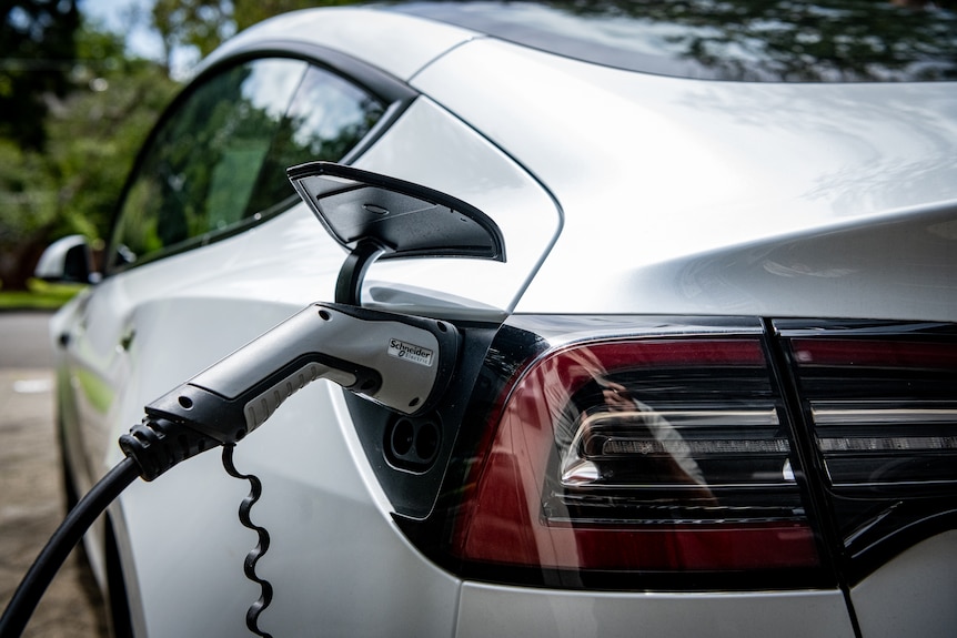 A charger plugged into an EV.