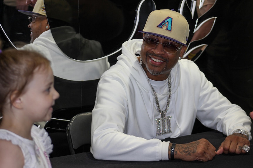 Allan Iverson smiles at a young fan.