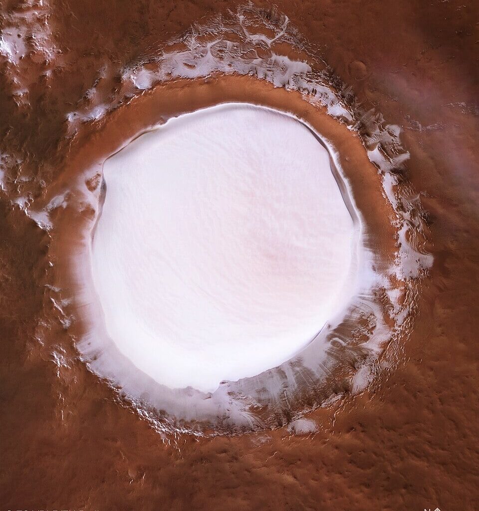 Mars contains water, though mostly as subsurface permafrost. Surface water is readily visible at some places, such as the ice-filled Korolev Crater, near the north polar ice cap (Credit : ESA/DLR/FU)