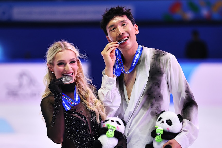 Holly Harris and Jason Chan bite their medals