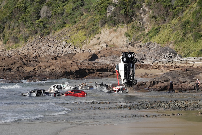 A car being winched from the sea by a helicopter along the Great Ocean Road.