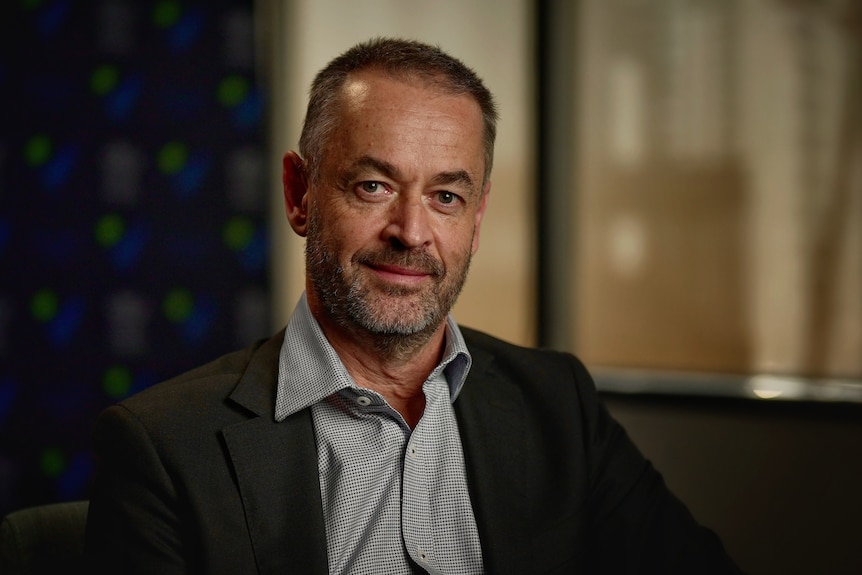 Dr David Rosengren smiles for a portrait indoors.
