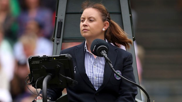 Umpire Kelly Rask looks on.