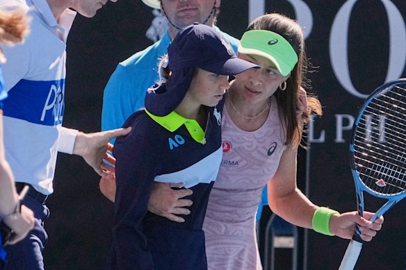 Zeynep Sonmez of Turkey and umpire Chase Urban help a ball kid who fainted.
