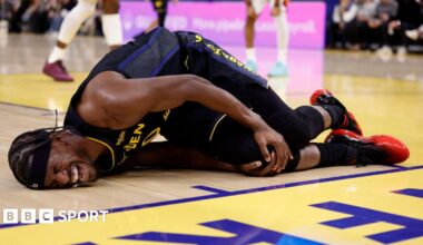 Golden State Warriors forward Jimmy Butler lies on the floor in agony, holding his right knee after tearing his ACL