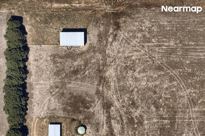 an aerial image of a farming property with three structures