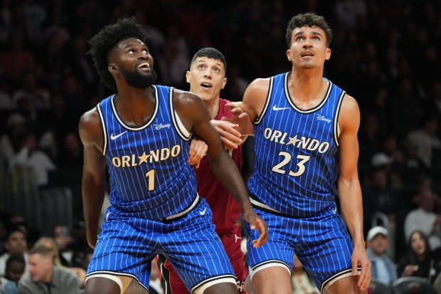 Miami Heat forward Simone Fontecchio (0) is pushed back by Orlando Magic forwards Jonathan Isaac (1) and Tristan da Silva (23) during the second half of an NBA basketball game Wednesday in Miami. (Marta Lavandier/Associated Press)