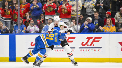 Dec 12, 2025; St. Louis, Missouri, USA; St. Louis Blues left wing Dylan Holloway (81) fights Chicago Blackhawks defenseman Connor Murphy (5) during the second period at Enterprise Center. Jeff Curry-Imagn Images