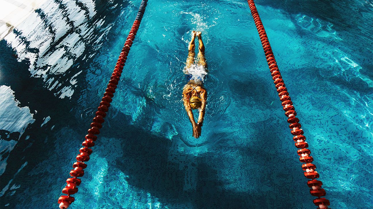 Person swimming between lanes in a swimming pool