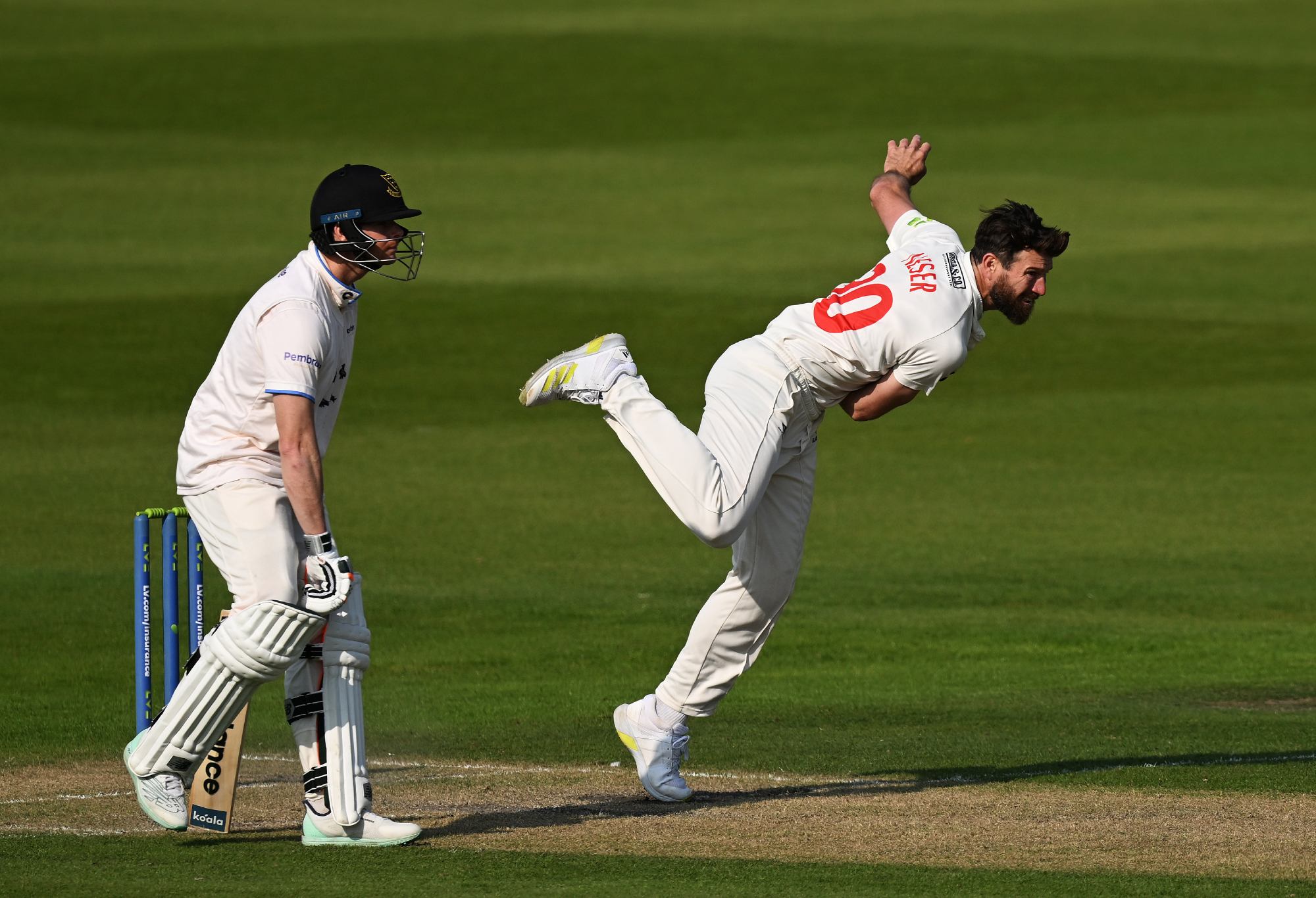 HOVE, ENGLAND - MAY 18: Michael Neser of Glamorgan bowls as fellow Australian Steve Smith of Sussex looks on during the LV= Insurance County Championship Division 2 match between Sussex and Glamorgan at The 1st Central County Ground on May 18, 2023 in Hove, England. (Photo by Mike Hewitt/Getty Images)