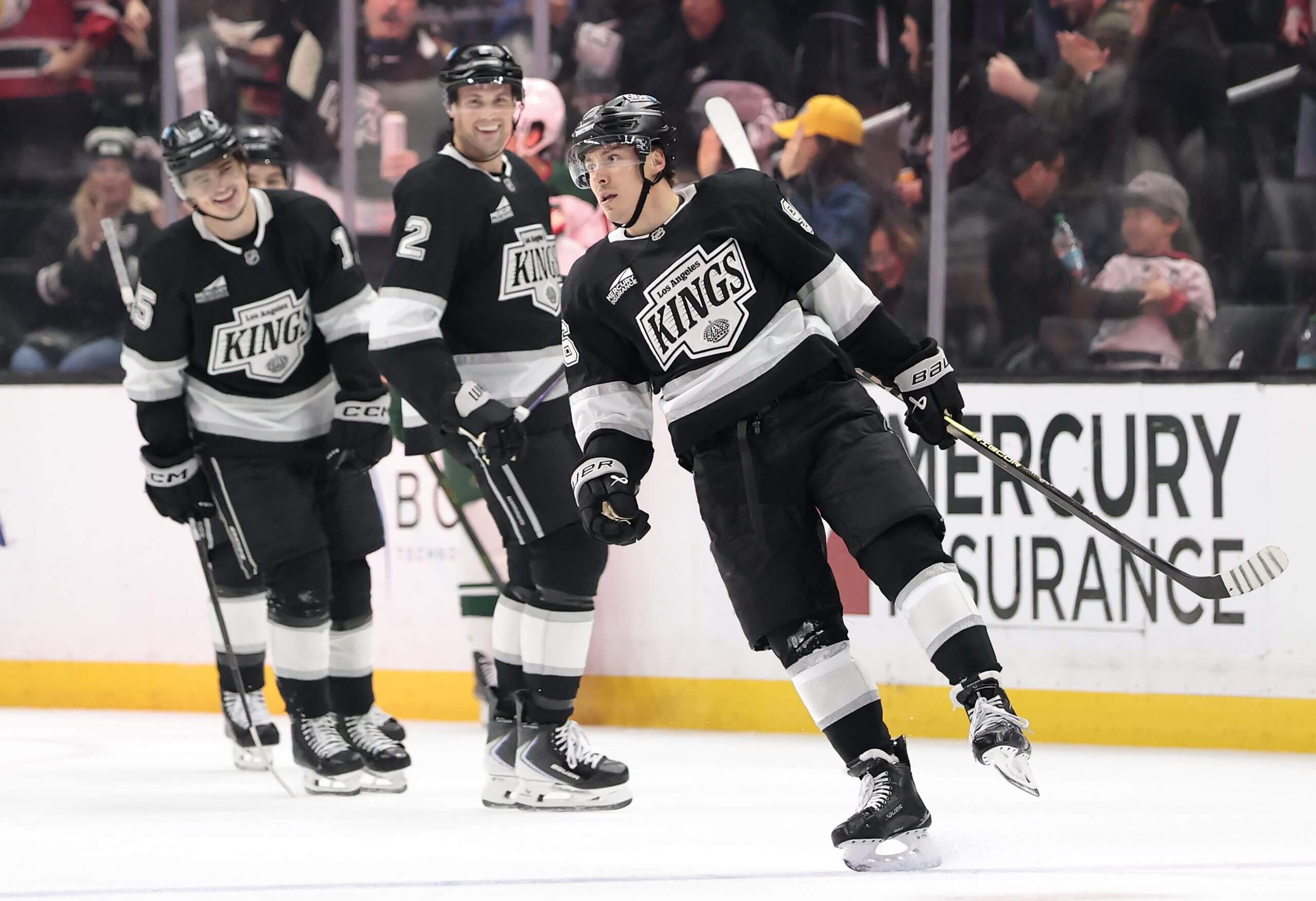 Andrei Kuzmenko celebrates a goal with three Kings teammates smiling behind him.