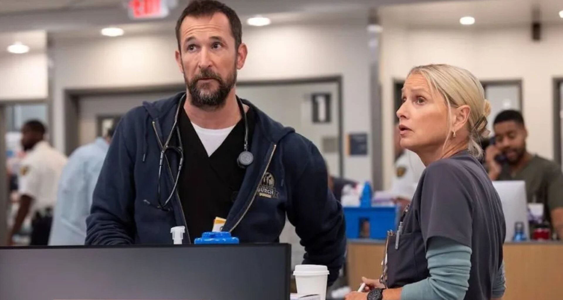 Robbie and Dana look at the ER screen above reception