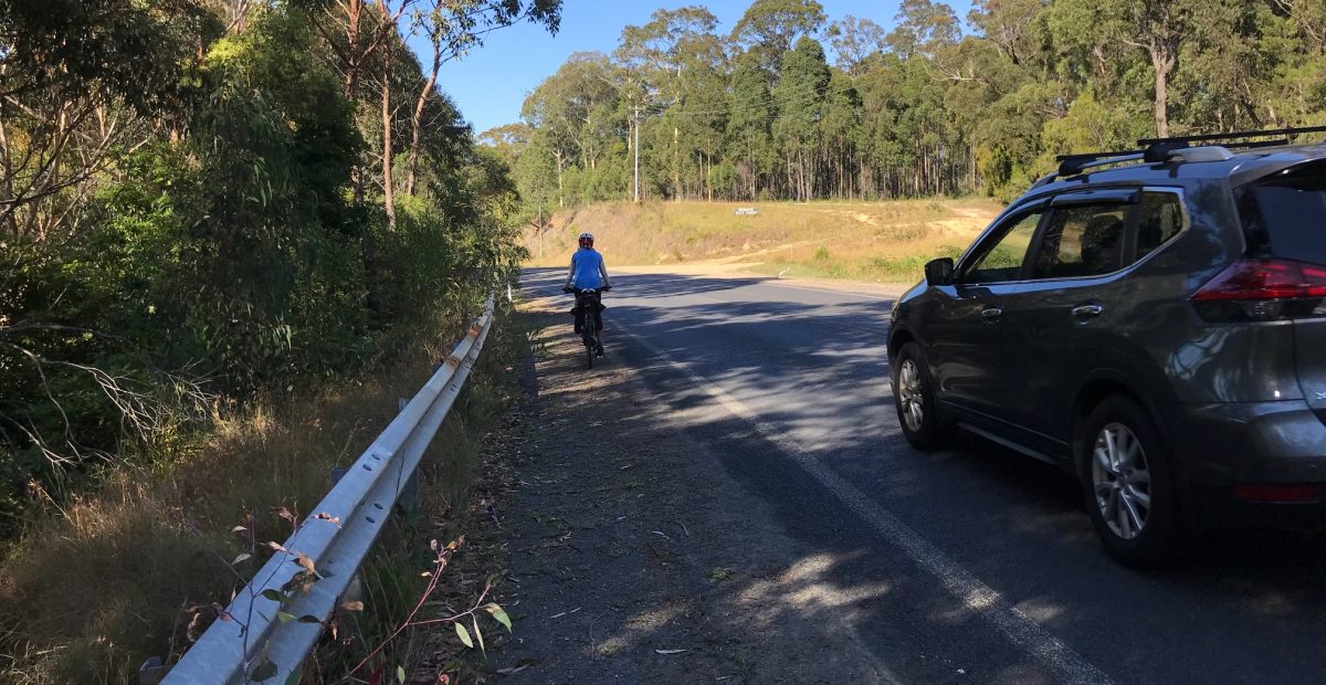 Cars pass very close to cyclists on the 80 km/h road.