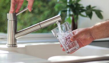 Close up of male hands pouring tap water into a glass in the kitchen