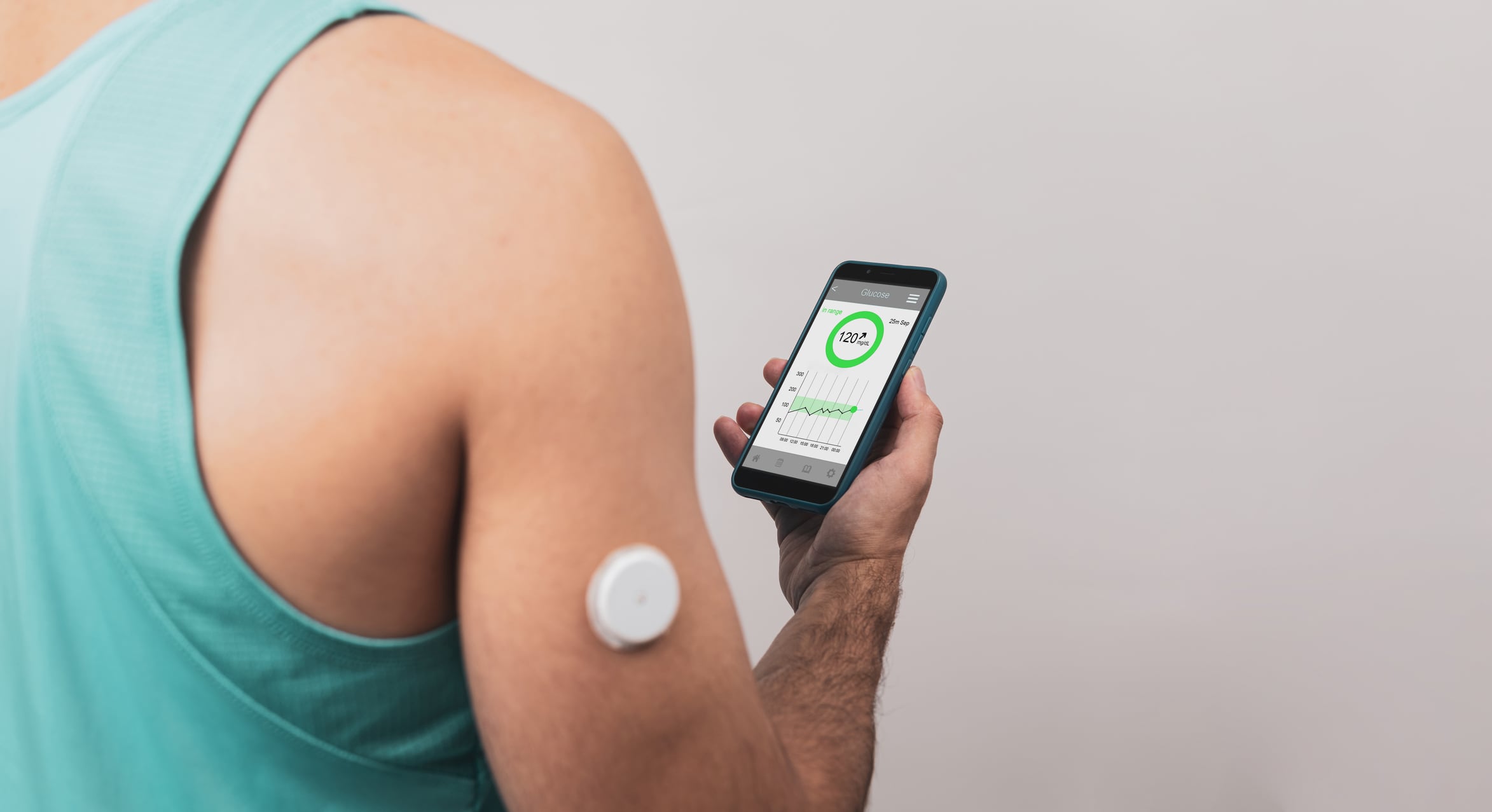 A man showing a Continuous Glucose Monitor (CGM) blood sugar test mobile app to measure his blood glucose levels.