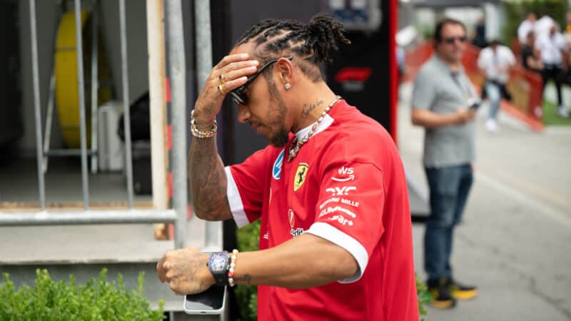 Lewis Hamilton puts his hand on his forehead in the F1 paddock at the 2025 Azerbaijan Grand Prix