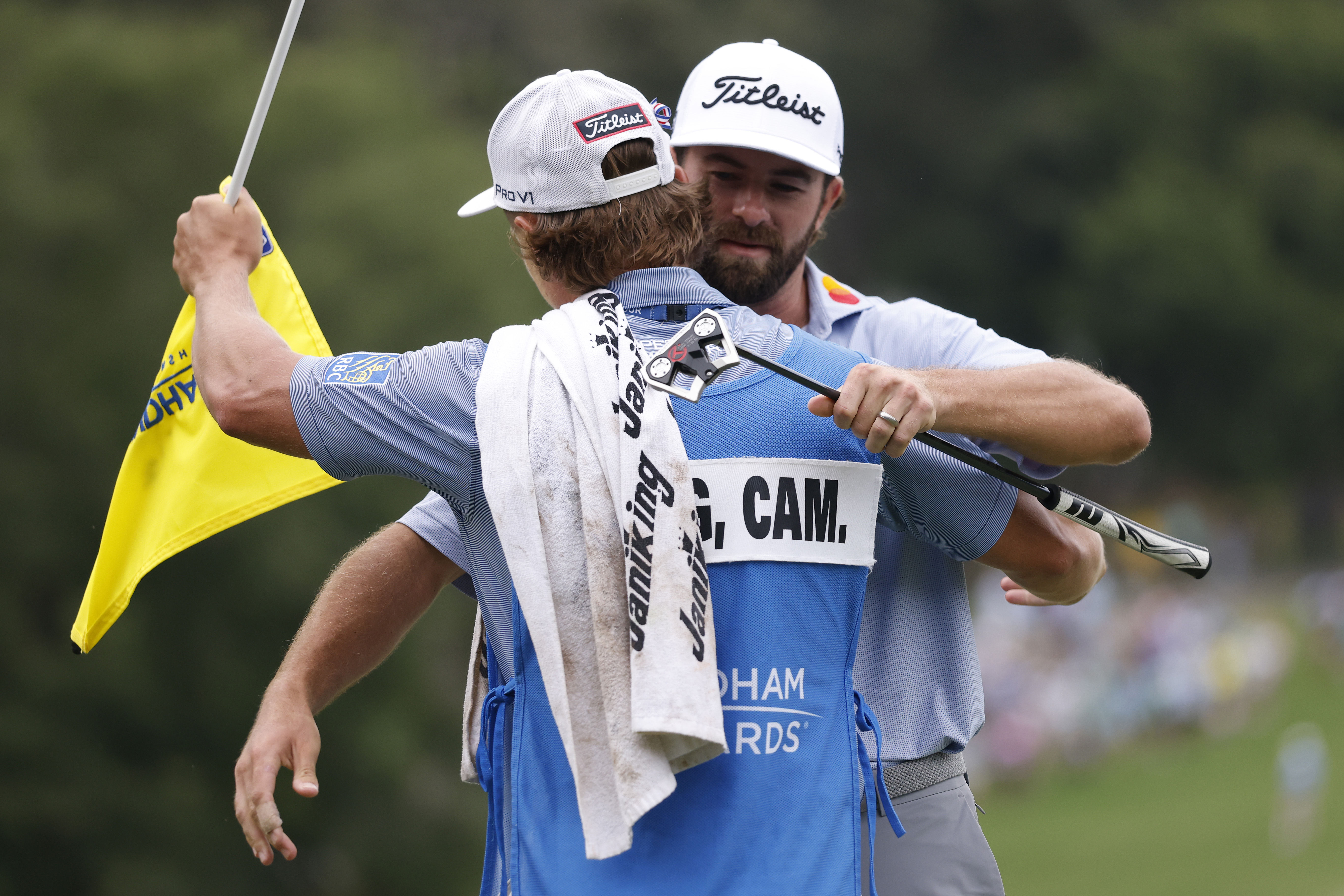 Cameron Young celebrates with his caddie after winning the Wyndham Championship