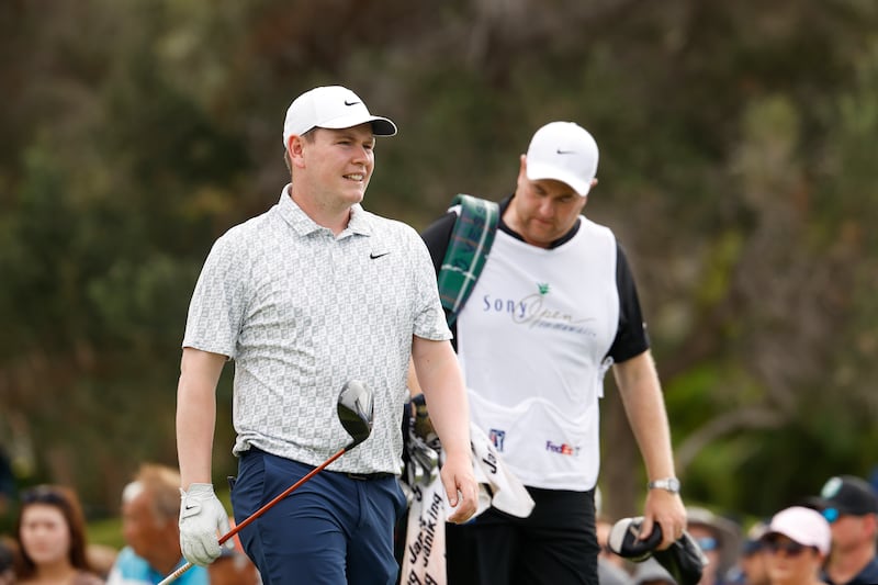Robert MacIntyre of Scotland and caddie Michael Burrow prepare to play his shot from the first tee in Hawaii. Photograph: Cliff Hawkins/Getty