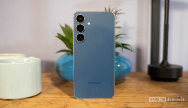 Samsung Galaxy S25 FE in Navy standing in front of plant