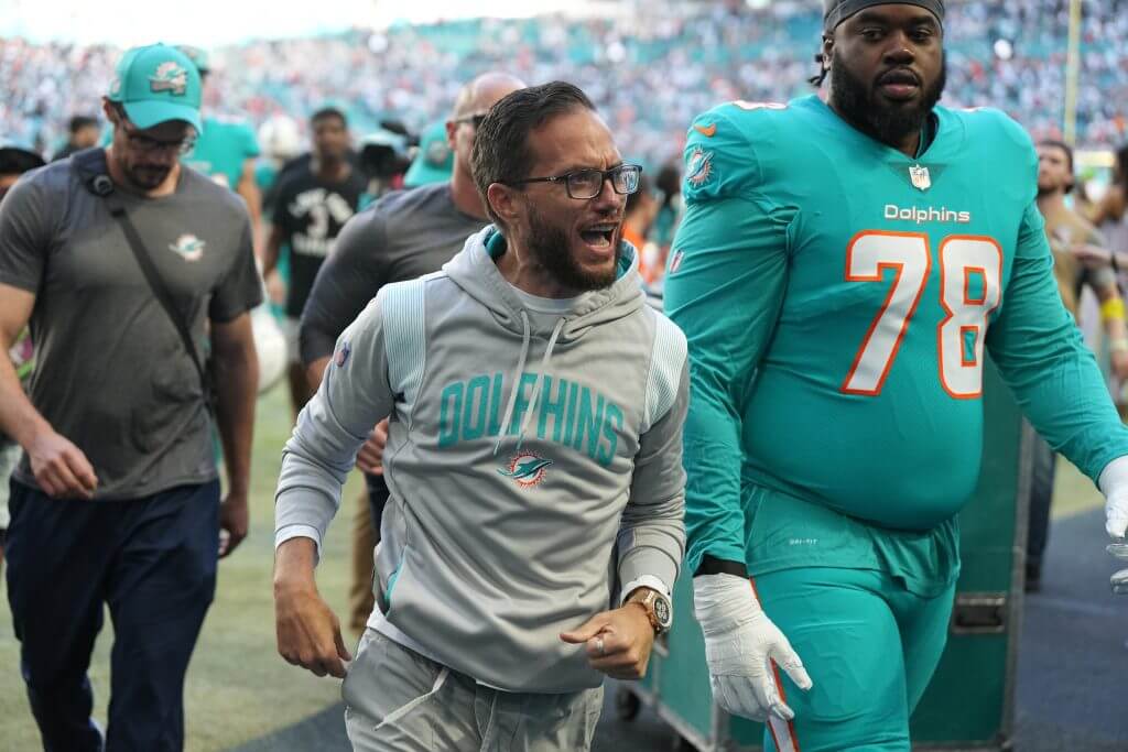 Mike McDaniel exits the field with the Dolphins after a win in 2023.