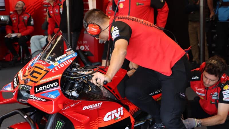 A Marquez mechanic compresses the GP25’s rear end, while pulling lever #1