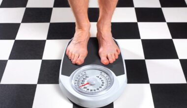 Senior obese man measuring his weight on bathroom scales