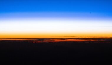 A sunset showing the black curve of the Earth with a golden band of light just above and a blue band of light above that