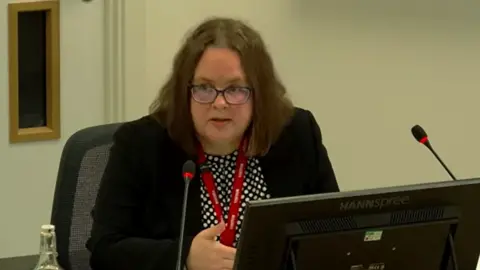 Scottish Hospitals Inquiry Dr Teresa Inkster sitting in front of a computer monitor, speaking into a microphone