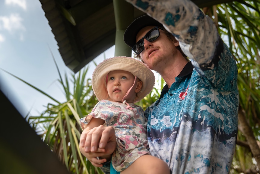 A man points something out to his baby