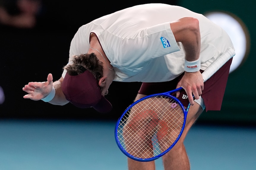 Alex de Minaur slaps his right leg during an Australian Open match.