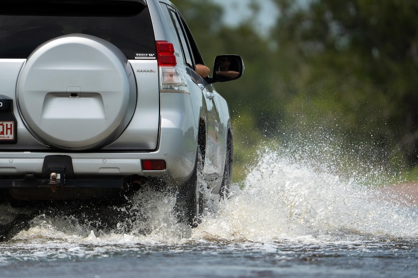 A four-wheel-drive drives through water