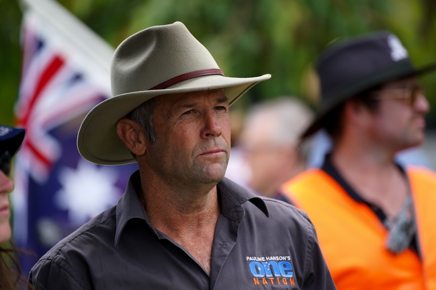 A man in a hat surrounded by orange flags