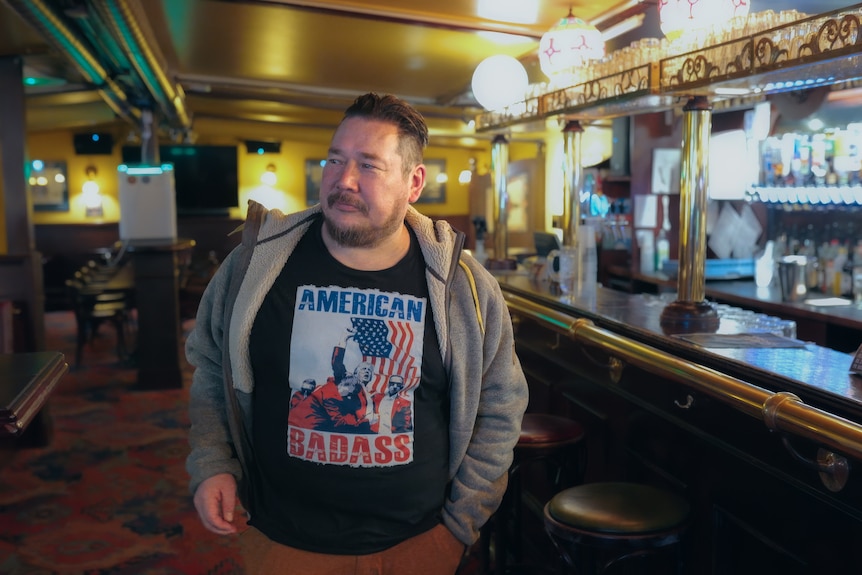 A man in a shirt with the writing 'American Badass'.