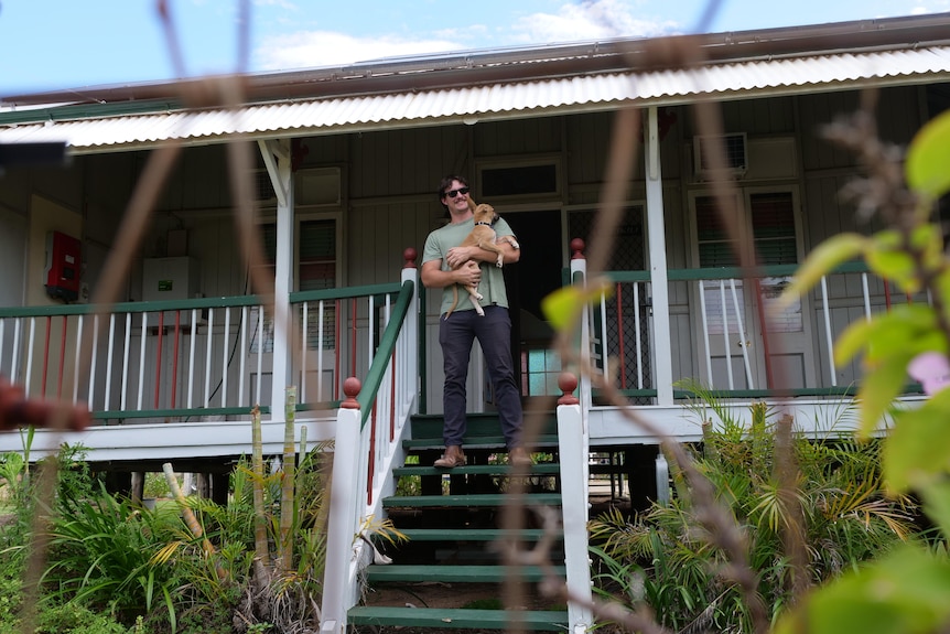 man standing on steps of Queenslander home 