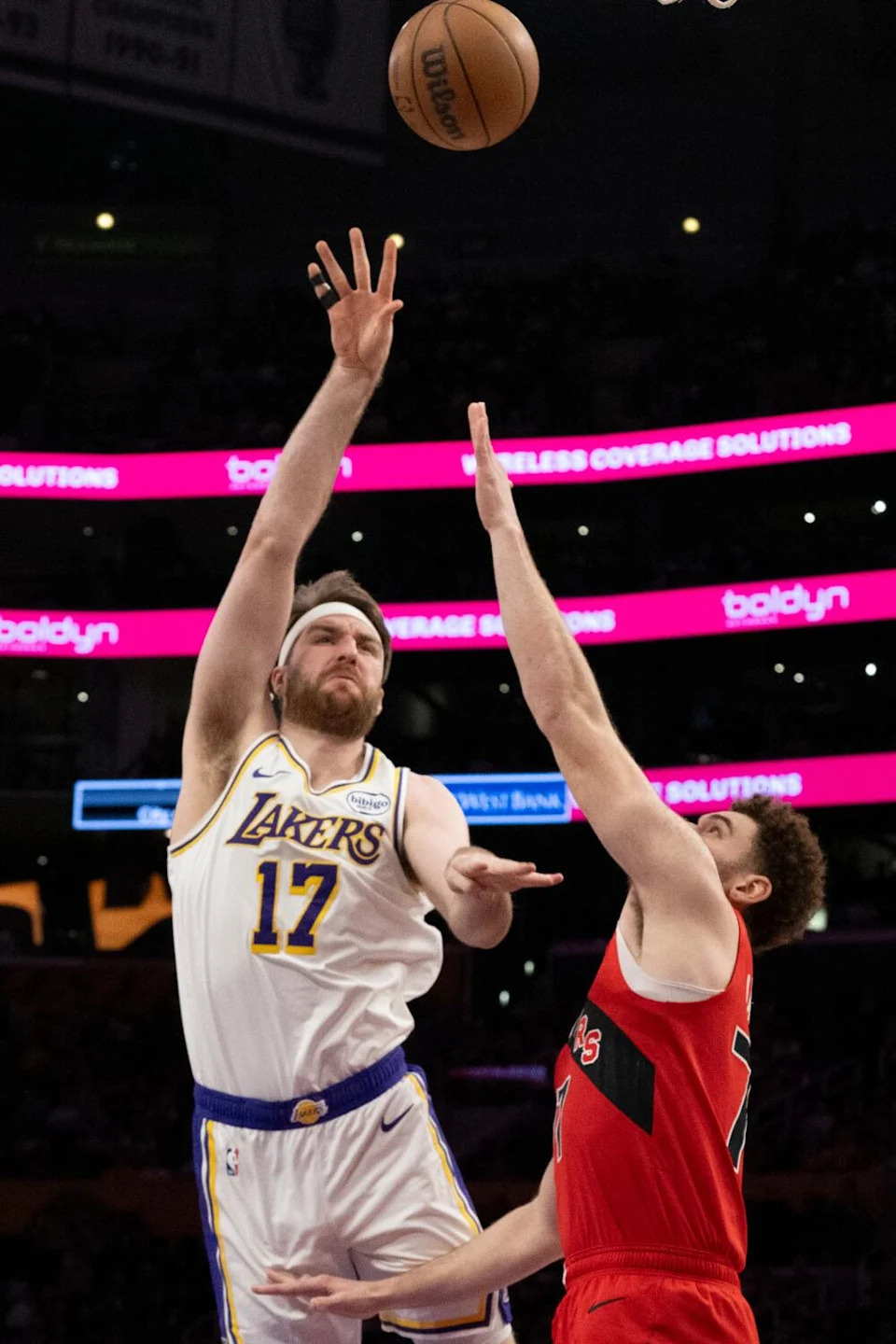 Lakers forward Drew Timme shoots under pressure from Toronto Raptors forward Jamison Battle at Crypto.com Arena.