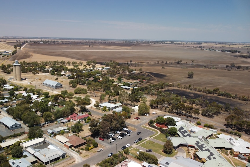 view from above of houses with blackened paddocks close to a row of homes and buildings
