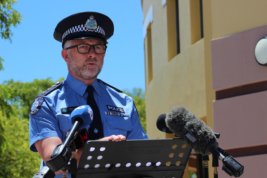 A man dressed in police uniform behind a lectern 