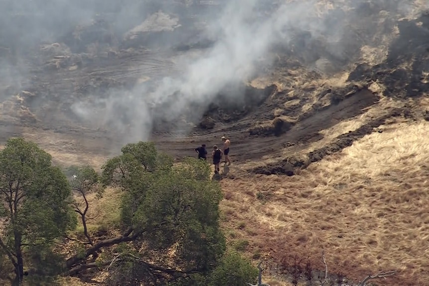 Flames near a structure with a white roof 