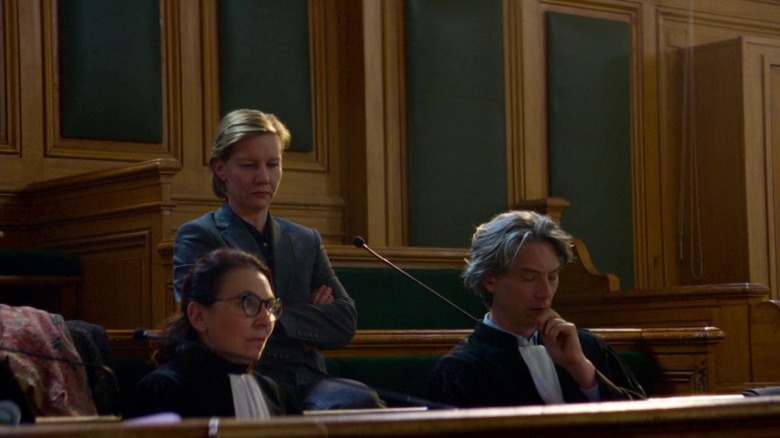 Sandra Hüller as Sandra, Saadia Bentaïeb as Nour, and Swann Arlaud as Vincent sitting together in the courtroom in Anatomy of a Fall