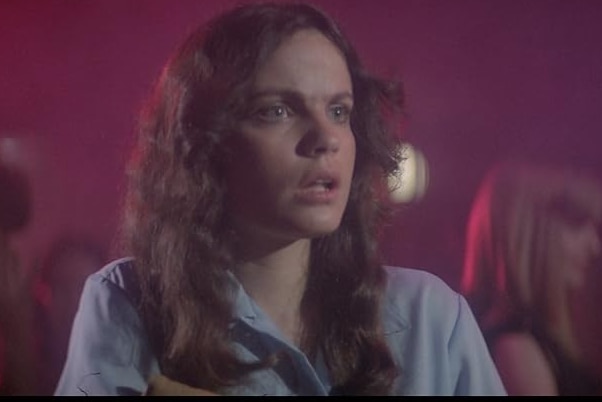 A woman looks shocked in a theatre