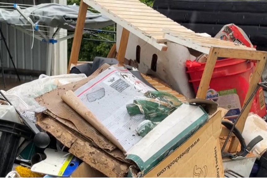 A pul of rubbish being loaded into a skip bin. 