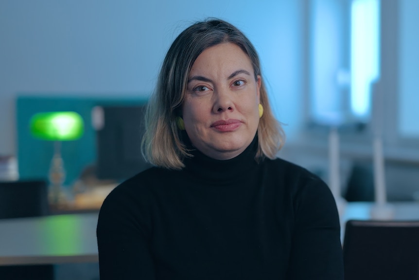 A woman looks at the camera.