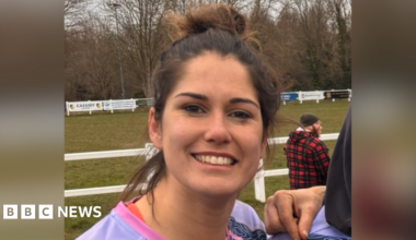A picture of Annette Bevan in her rugby kit, stood in front of a rugby pitch.