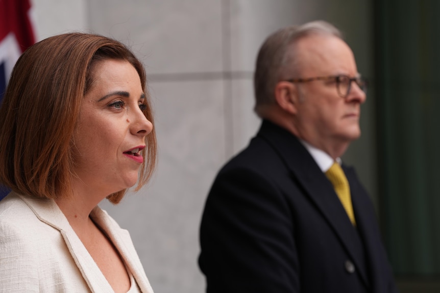 Anika Wells (left) wearing a white suit jacket, Anthony Albanese (right) wearing a dark jacket.